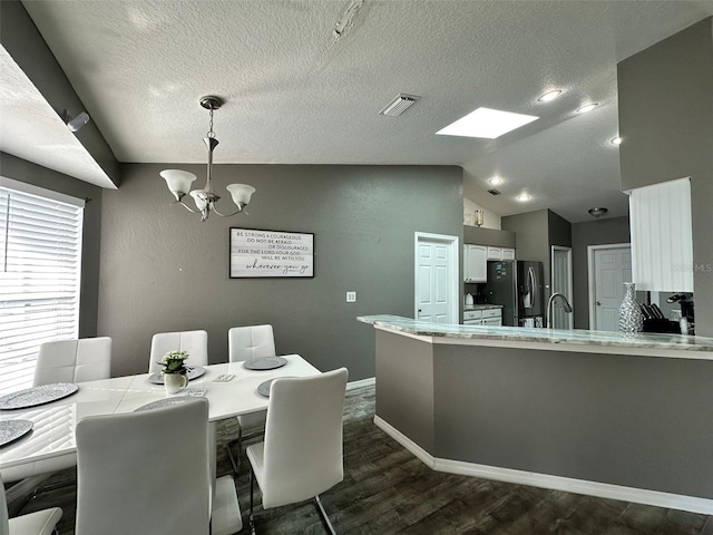 2410 Sweetwater Blvd, Saint Cloud, FL 34772 - dining space featuring a chandelier, dark wood-type flooring, vaulted ceiling, a textured ceiling, and baseboards