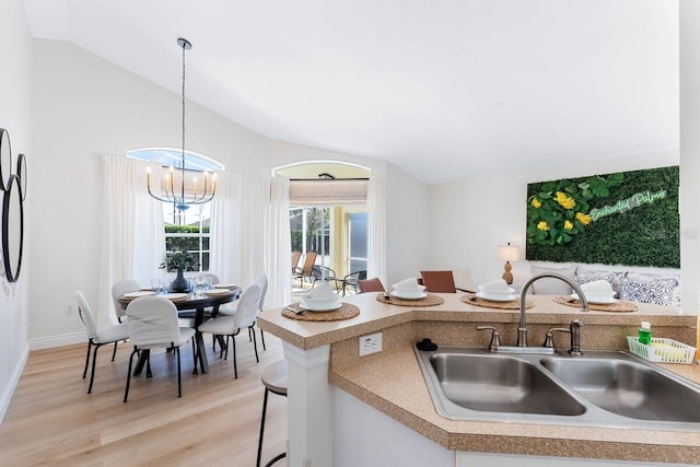 344 High Point Dr, Davenport, FL 33837 - kitchen featuring a sink, vaulted ceiling, light wood-type flooring, light countertops, and a chandelier