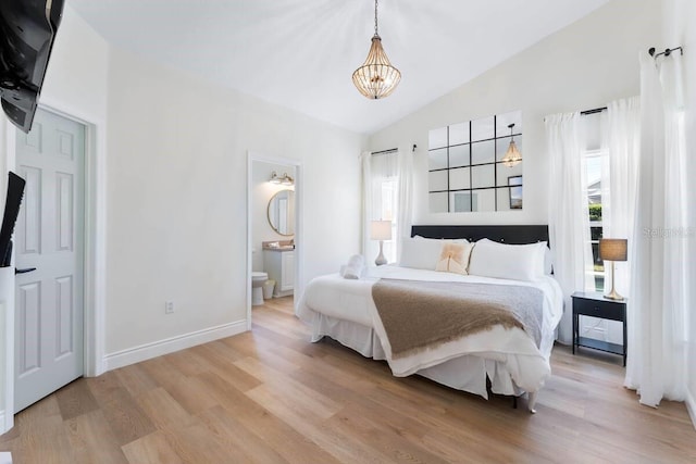 344 High Point Dr, Davenport, FL 33837 - bedroom with a chandelier, light wood finished floors, connected bathroom, and baseboards