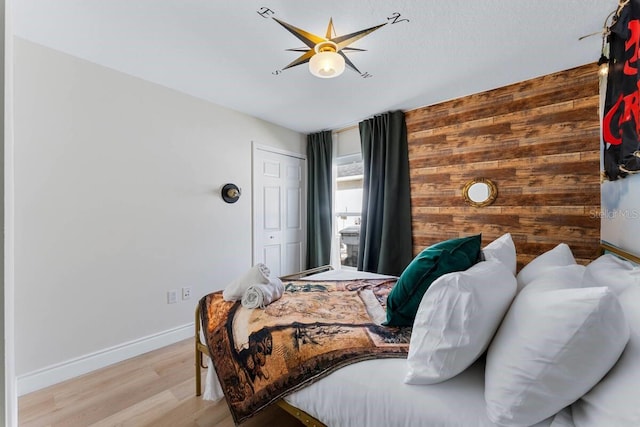 344 High Point Dr, Davenport, FL 33837 - bedroom with wooden walls, light wood finished floors, baseboards, and a ceiling fan