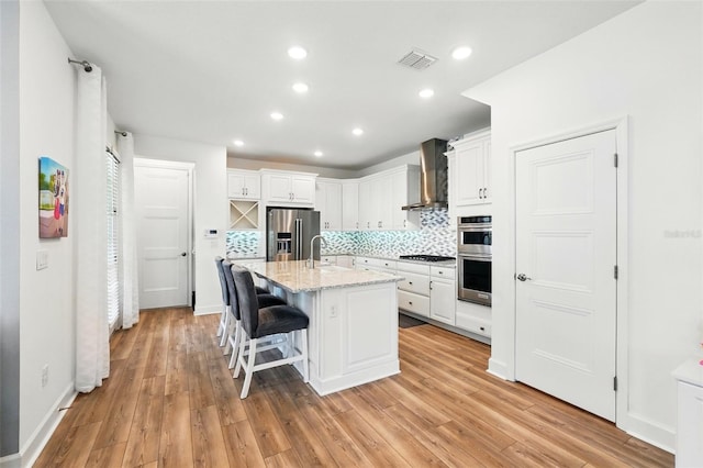 7400 Estuary Lake Loop, Celebration, FL 34747 - kitchen featuring appliances with stainless steel finishes, wall chimney exhaust hood, white cabinetry, decorative backsplash, and recessed lighting