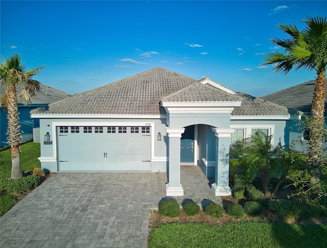 1508BUNKERDRIVE Bunker, Davenport, FL 33896 - view of front of house featuring an attached garage, a tile roof, and stucco siding