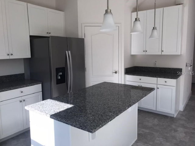 13885 Arclid St, Orlando, FL 32832 - kitchen featuring stainless steel refrigerator with ice dispenser, white cabinetry, hanging light fixtures, a center island, and dark stone countertops
