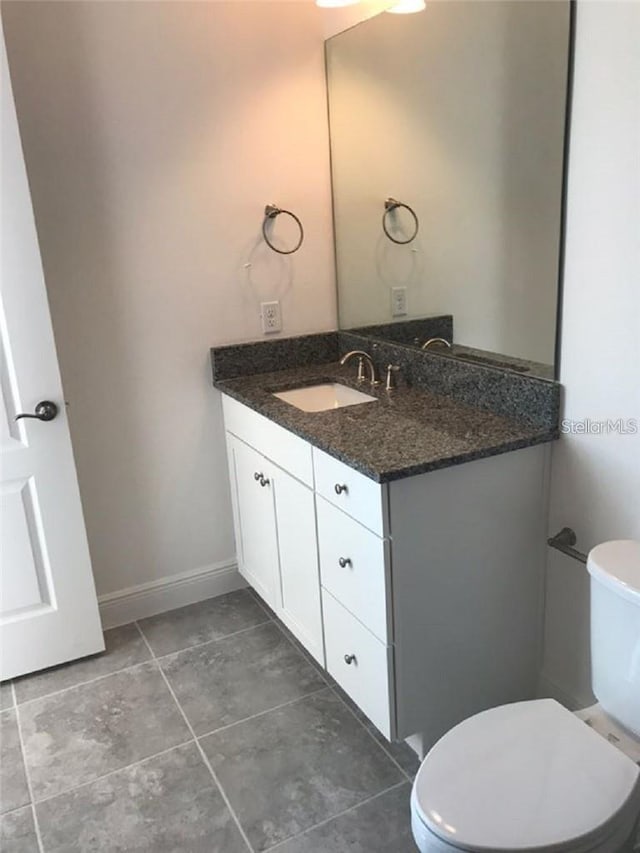 13885 Arclid St, Orlando, FL 32832 - half bathroom with vanity, toilet, tile patterned flooring, and baseboards