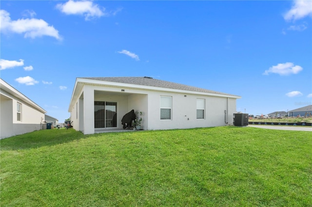 1524 Fleur Dr, Davenport, FL 33837 - rear view of house with stucco siding, cooling unit, and a yard
