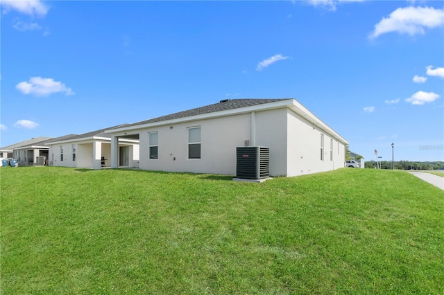 1524 Fleur Dr, Davenport, FL 33837 - back of property with central air condition unit, stucco siding, and a yard