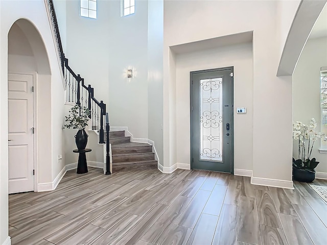 1211 Terralago Way, Kissimmee, FL 34746 - foyer with wood finished floors, arched walkways, a high ceiling, baseboards, and plenty of natural light