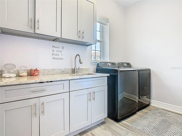 1211 Terralago Way, Kissimmee, FL 34746 - laundry room featuring washing machine and clothes dryer, light wood-type flooring, cabinet space, and baseboards