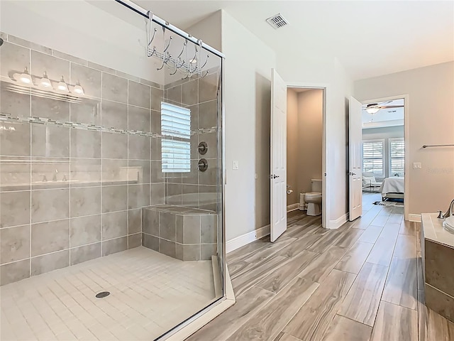 1211 Terralago Way, Kissimmee, FL 34746 - ensuite bathroom featuring a stall shower, toilet, wood finished floors, and baseboards