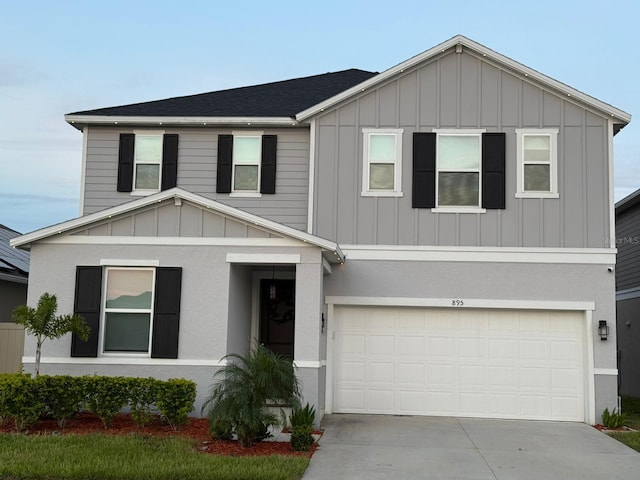 895 Overpool Ave, Davenport, FL 33896 - view of front of property featuring board and batten siding, concrete driveway, a garage, and a shingled roof