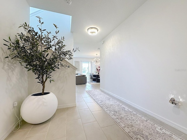 895 Overpool Ave, Davenport, FL 33896 - corridor featuring a chandelier, tile patterned floors, and baseboards