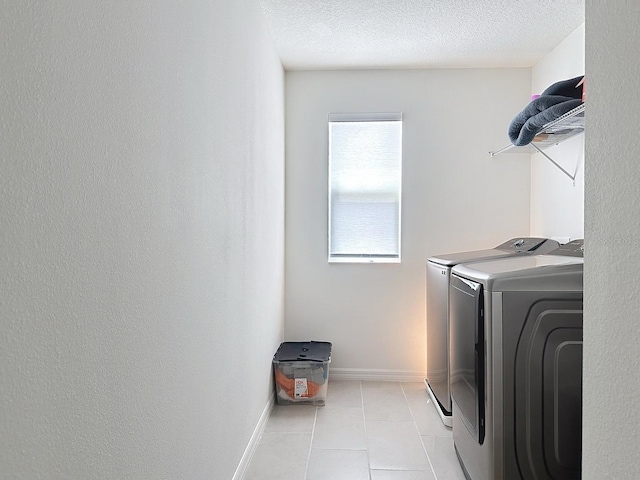 895 Overpool Ave, Davenport, FL 33896 - laundry room featuring washer and clothes dryer, light tile patterned floors, a textured ceiling, and baseboards