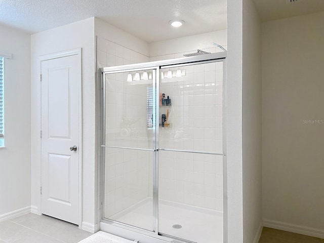 895 Overpool Ave, Davenport, FL 33896 - bathroom with a shower stall, tile patterned floors, baseboards, and a textured ceiling