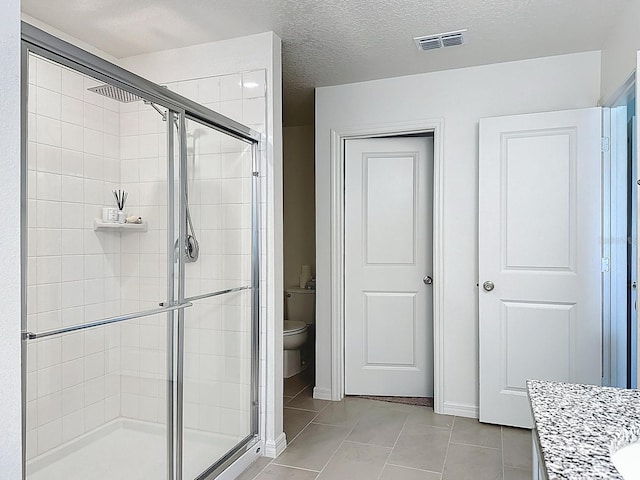 895 Overpool Ave, Davenport, FL 33896 - full bathroom featuring a shower stall, toilet, tile patterned floors, vanity, and a textured ceiling