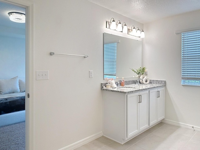 895 Overpool Ave, Davenport, FL 33896 - bathroom featuring vanity, ensuite bath, baseboards, tile patterned flooring, and a textured ceiling