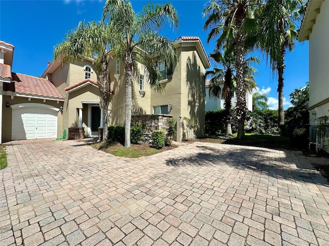 833 Brunello Dr, Davenport, FL 33897 - mediterranean / spanish-style home with stucco siding, decorative driveway, an attached garage, and a tiled roof