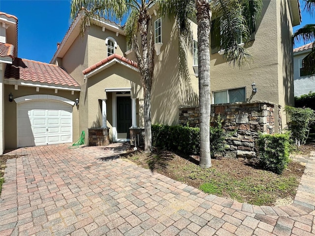 833 Brunello Dr, Davenport, FL 33897 - mediterranean / spanish-style home with stucco siding, a garage, a tile roof, and decorative driveway