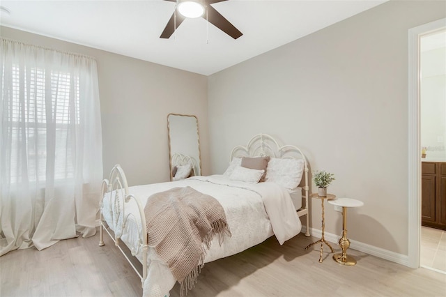 8042 Glenlloyd Ave, Winter Garden, FL 34787 - bedroom with light wood-style floors, ensuite bath, baseboards, and ceiling fan