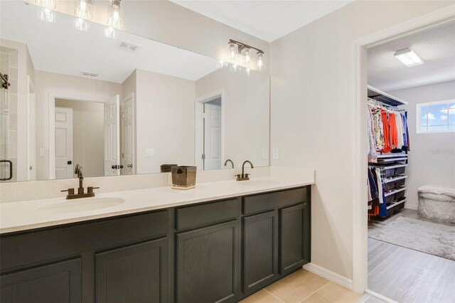 8042 Glenlloyd Ave, Winter Garden, FL 34787 - full bathroom with double vanity, a spacious closet, baseboards, and a shower with door