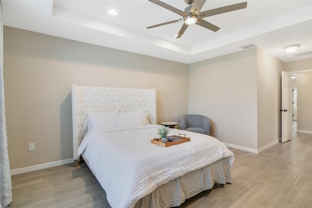 8042 Glenlloyd Ave, Winter Garden, FL 34787 - bedroom with a tray ceiling, light wood-style floors, baseboards, a ceiling fan, and recessed lighting