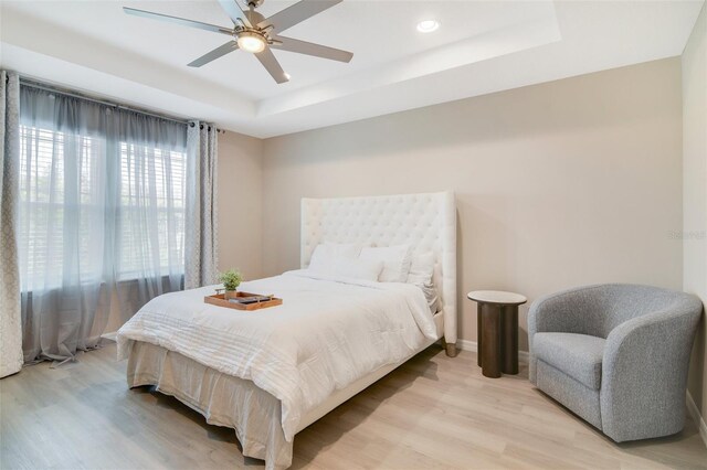 8042 Glenlloyd Ave, Winter Garden, FL 34787 - bedroom featuring a tray ceiling, light wood finished floors, baseboards, recessed lighting, and ceiling fan