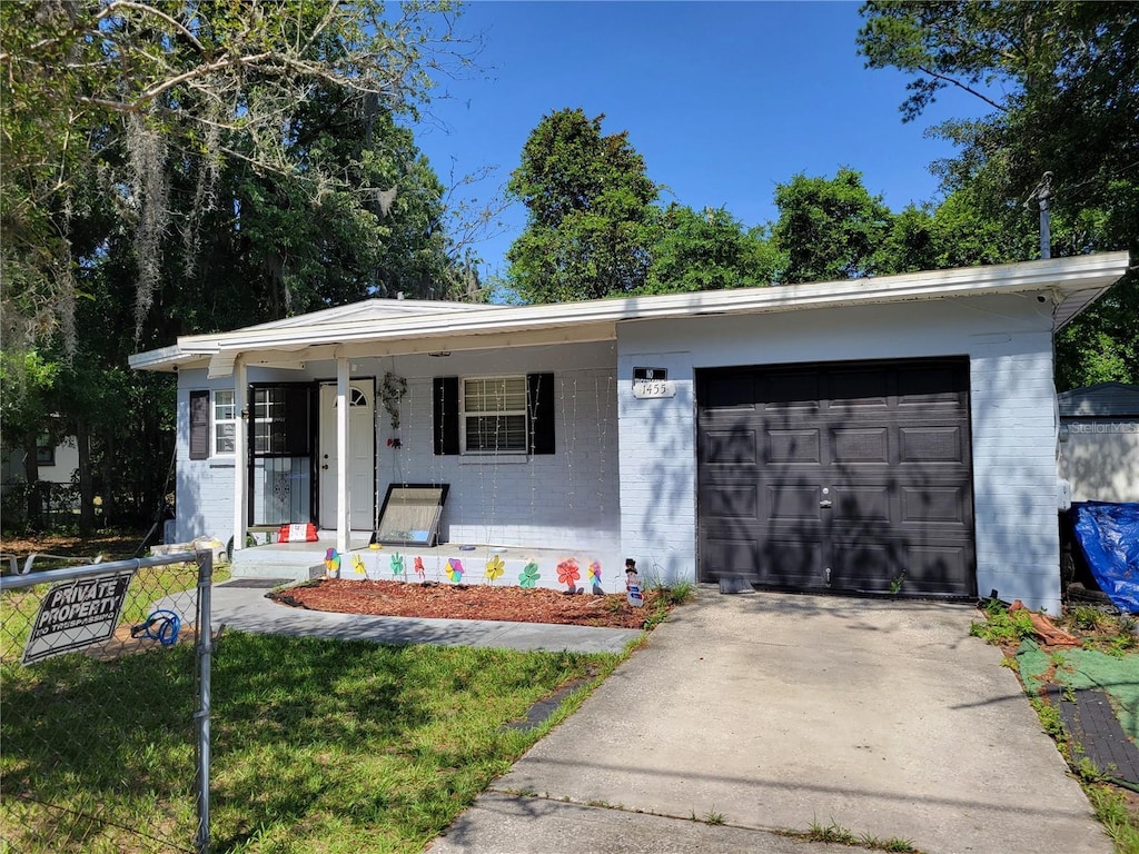 1455 Floyd Cir E, Orange Park, FL 32073 - view of front of property featuring brick siding, a porch, an attached garage, driveway, and a front lawn