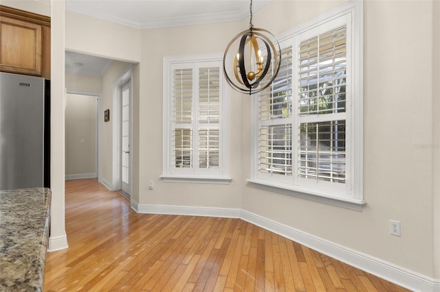 3349 Schoolhouse Rd, Harmony, FL 34773 - unfurnished dining area featuring a chandelier, light wood-type flooring, crown molding, and baseboards