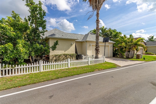 3349 Schoolhouse Rd, Harmony, FL 34773 - view of front facade with driveway, stucco siding, an attached garage, and a fenced front yard