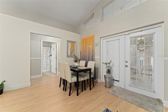 2507 Talega Dr, Saint Cloud, FL 34772 - dining space with french doors, light wood-type flooring, baseboards, and high vaulted ceiling