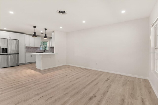 1842 Puritan Ave, Winter Park, FL 32792 - kitchen featuring stainless steel fridge with ice dispenser, recessed lighting, light wood-style floors, light countertops, and decorative backsplash
