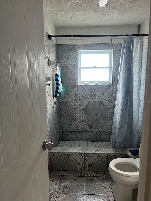 1009 Kenmore Dr, Brandon, FL 33510 - bathroom featuring a shower stall, toilet, a textured ceiling, and tile patterned flooring