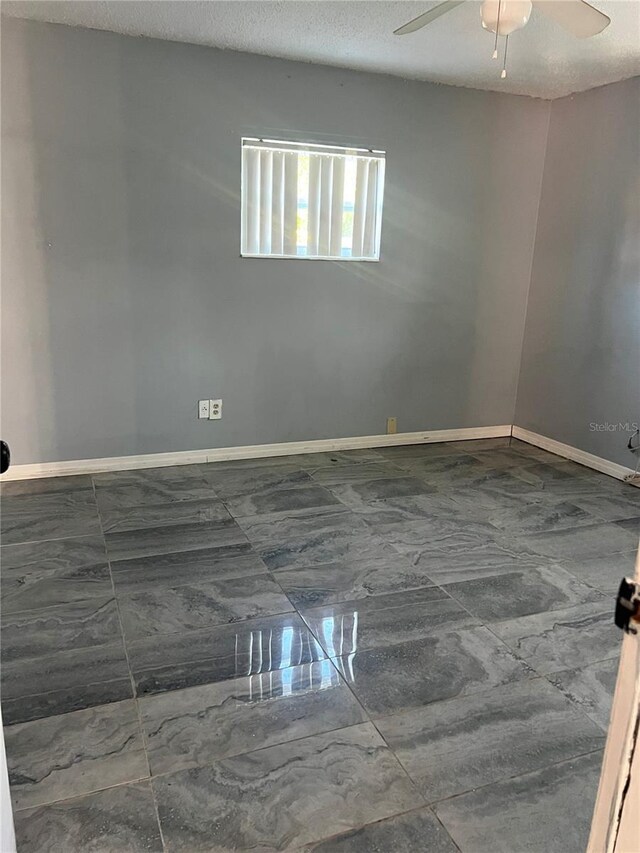 1009 Kenmore Dr, Brandon, FL 33510 - spare room featuring ceiling fan, baseboards, marble finish flooring, and a textured ceiling
