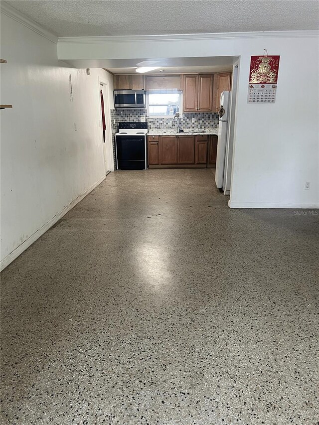 1009 Kenmore Dr, Brandon, FL 33510 - kitchen featuring electric range oven, stainless steel microwave, crown molding, freestanding refrigerator, and light countertops