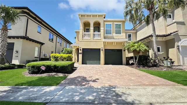 1228 Castle Pines Ct, Reunion, FL 34747 - view of front of home with a garage, decorative driveway, stucco siding, and a balcony