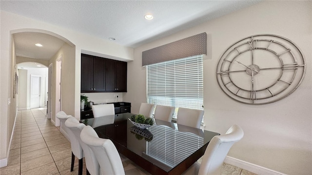1228 Castle Pines Ct, Reunion, FL 34747 - dining area featuring light tile patterned floors, arched walkways, baseboards, and recessed lighting