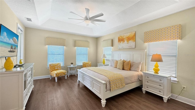 1228 Castle Pines Ct, Reunion, FL 34747 - bedroom with a tray ceiling, dark wood finished floors, baseboards, ceiling fan, and a textured ceiling