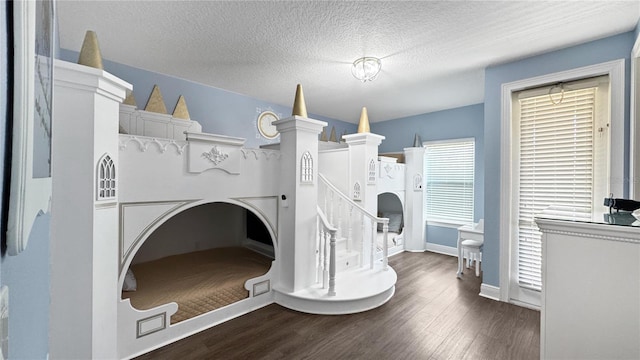 1228 Castle Pines Ct, Reunion, FL 34747 - laundry area featuring dark wood-style flooring, a textured ceiling, and baseboards