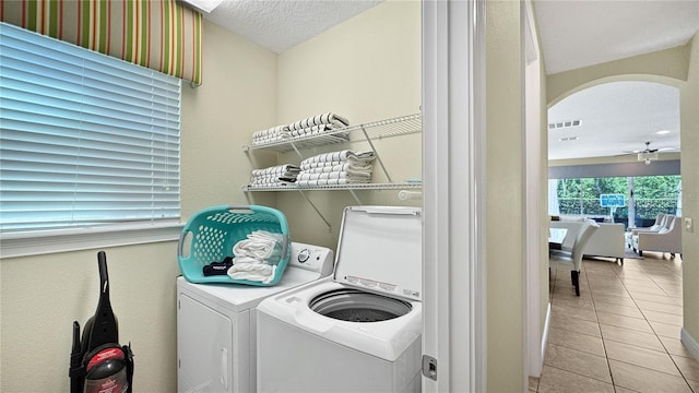 1228 Castle Pines Ct, Reunion, FL 34747 - washroom featuring washing machine and dryer, tile patterned flooring, a textured ceiling, and arched walkways