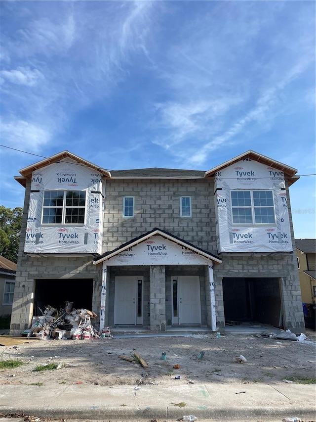 1308 Verona St Unit 1308 & 1310, Kissimmee, FL 34741 - unfinished property featuring an attached garage, stone siding, and driveway