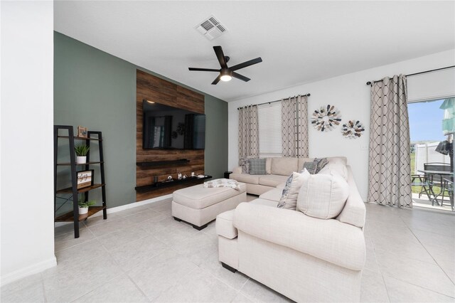 1113 Merrill St, Davenport, FL 33837 - living room featuring a ceiling fan, wooden walls, an accent wall, light tile patterned floors, and baseboards