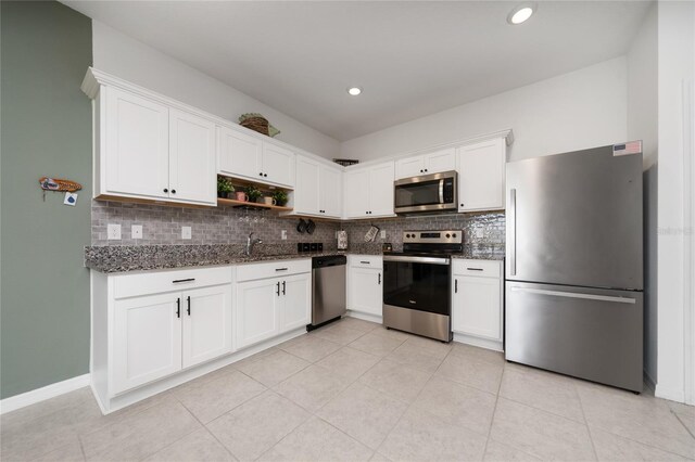 1113 Merrill St, Davenport, FL 33837 - kitchen featuring appliances with stainless steel finishes, decorative backsplash, dark stone counters, white cabinets, and open shelves