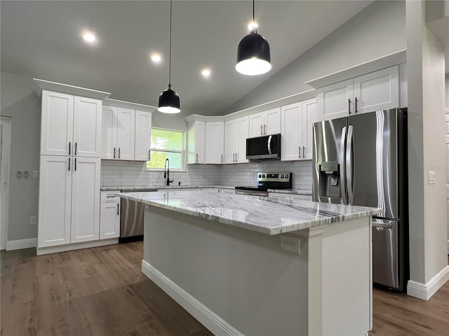 814 Gator Ln, Deltona, FL 32738 - kitchen featuring stainless steel appliances, tasteful backsplash, white cabinetry, vaulted ceiling, and a center island