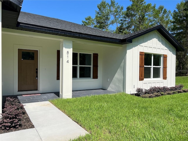 814 Gator Ln, Deltona, FL 32738 - entrance to property with a shingled roof, board and batten siding, and a yard