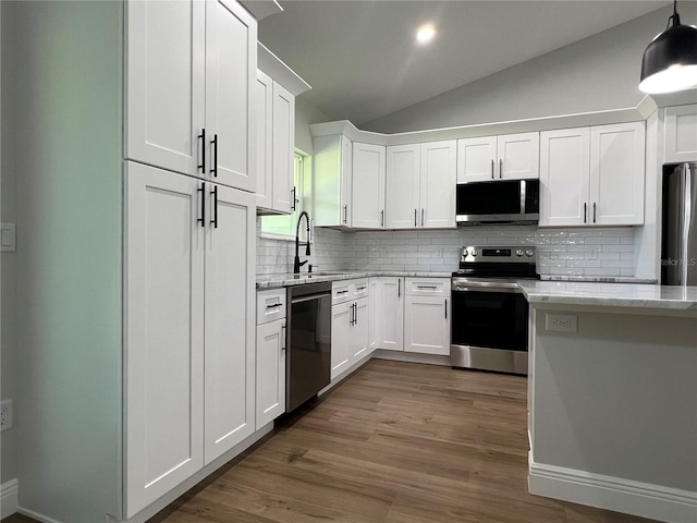 814 Gator Ln, Deltona, FL 32738 - kitchen with appliances with stainless steel finishes, a sink, decorative backsplash, lofted ceiling, and white cabinets