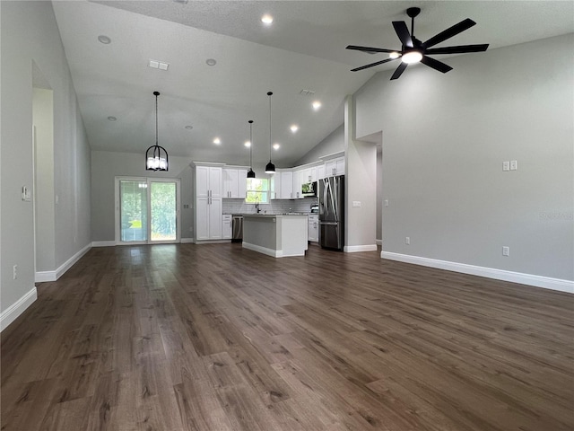 814 Gator Ln, Deltona, FL 32738 - unfurnished living room with a ceiling fan, baseboards, high vaulted ceiling, dark wood-style flooring, and a sink