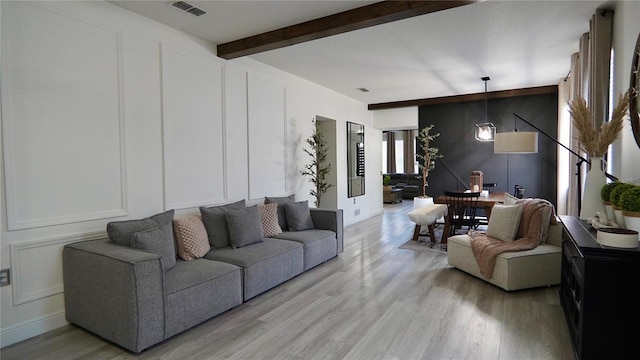 1025 Belvoir Dr, Kissimmee, FL 34744 - living area featuring a decorative wall, light wood-style floors, beam ceiling, and an accent wall