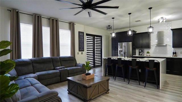 1025 Belvoir Dr, Kissimmee, FL 34744 - living room with a ceiling fan, healthy amount of natural light, and light wood-type flooring