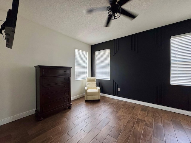 1025 Belvoir Dr, Kissimmee, FL 34744 - sitting room with a ceiling fan, dark wood-style flooring, a textured ceiling, and baseboards