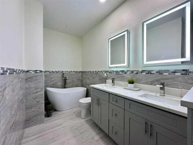 1025 Belvoir Dr, Kissimmee, FL 34744 - bathroom featuring tile walls, a freestanding bath, double vanity, and wainscoting