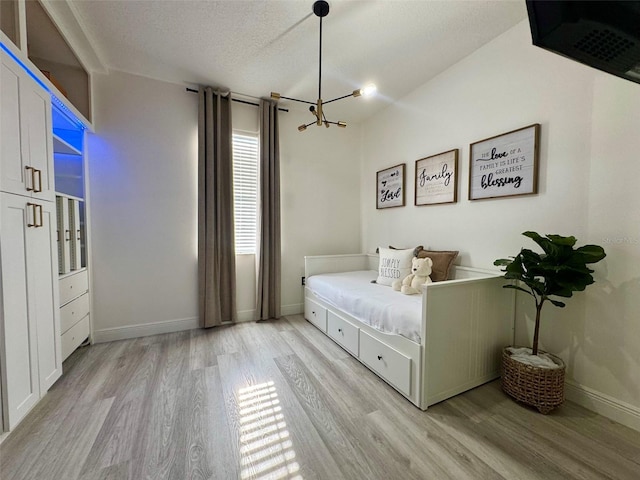 1025 Belvoir Dr, Kissimmee, FL 34744 - bedroom with light wood finished floors, baseboards, a chandelier, and a textured ceiling